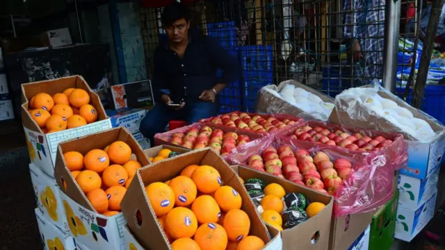 দোকানে মাল্টা ও আপেলসহ বিভিন্ন ফল দেখা যাচ্ছে